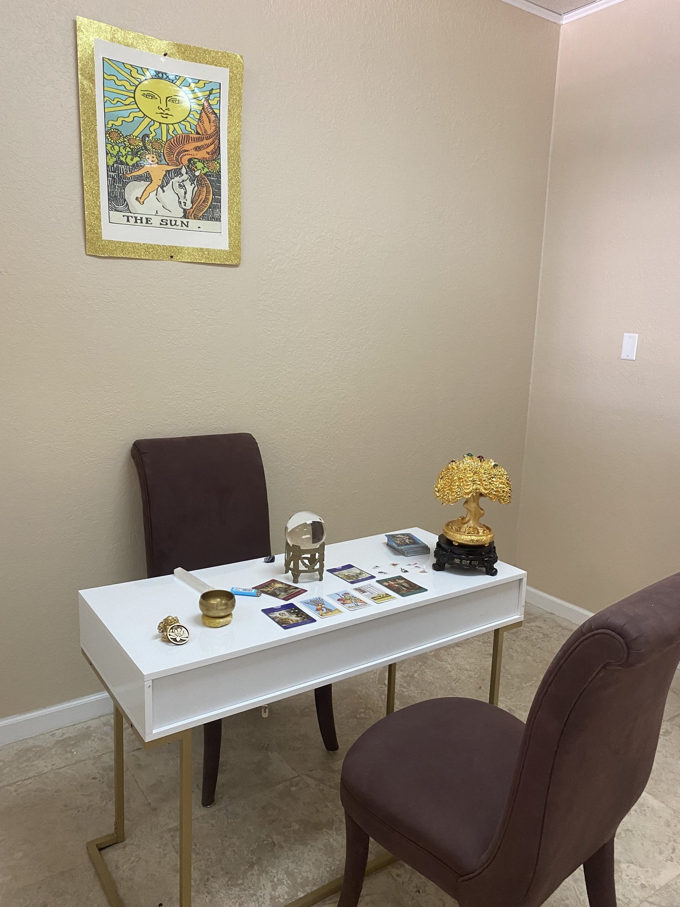 Georgia's reading table with crystal ball, tarot cards, and the Sun tarot card on the wall